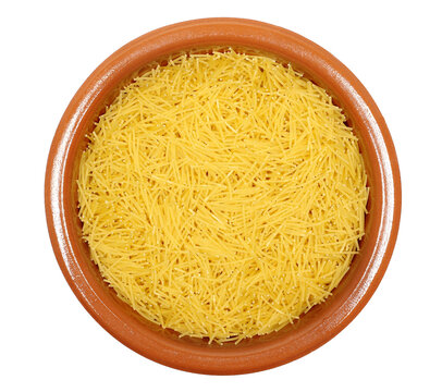 Uncooked durum wheat semolina pasta pile in clay pot isolated on white background, top view