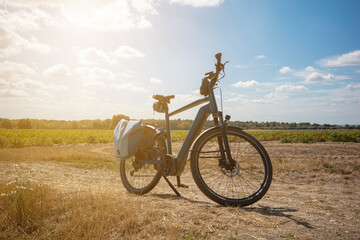 Fototapeta premium Bicycle parked on a dirt path near a field during sunny afternoon hours