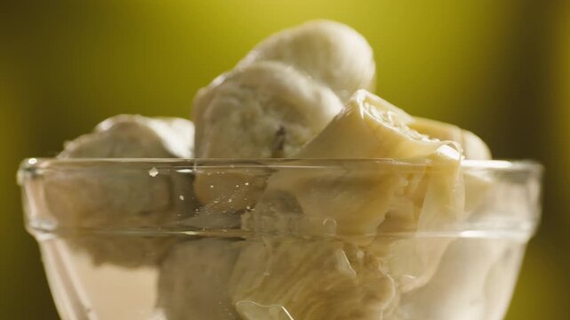 Artichoke hearts marinated in glass bowl, traditional Catalan vegetable appetizer, close-up macro shot