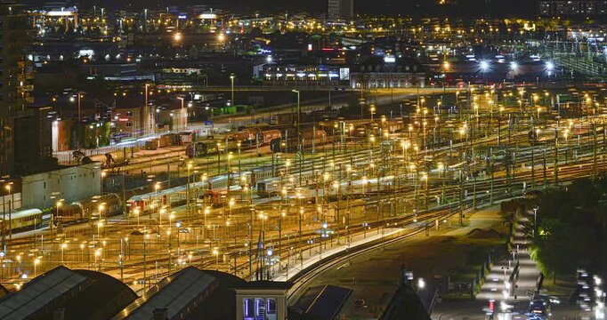 Illuminated railway yard and rail network across city at night