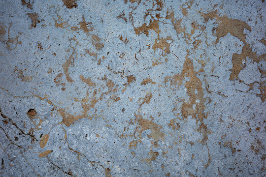 Close view of textured surface with light blue and brown colors showing roughness and patterns