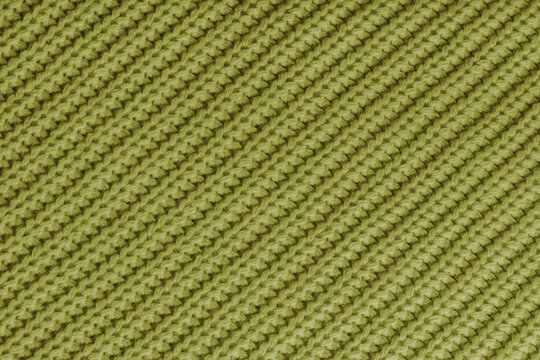 Close up, macro of khaki knitted fabric texture with visible diagonal yarn stitches and soft wool pattern. Cozy textile backdrop, cloth background, fashion wallpaper, winter clothing concepts