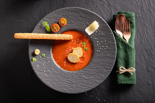 Exclusive and aromatic tomato soup as culinary artistry on plate.