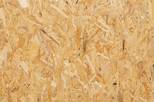 Close-up view of oriented strand board (OSB) surface showcasing wood strands and texture, ideal for construction and interior design applications