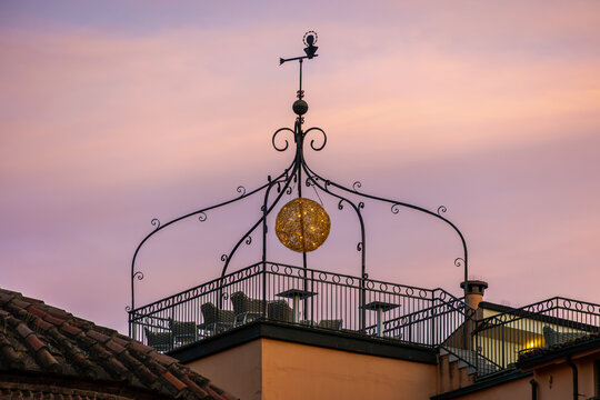 Ornate rooftop terrace with glowing hanging decoration at dusk, Italy, Lombardy, Mantua, 3 June 2026