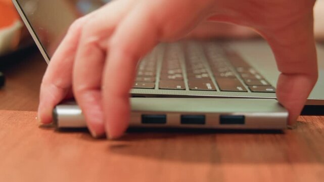 Closeup of hands coordinating peripherals. Detailed view of hands attaching external devices to computer. Closeup of hands carefully connecting multiple peripherals to laptop during work session