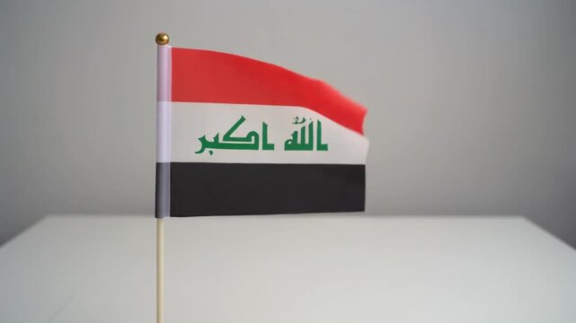 Small Iraq Flag Waving on White Table Desk Stand Isolated on Grey Background