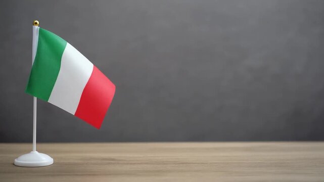 Small Italy Flag Waving on Wooden Table Desk Stand Isolated on Grey Background