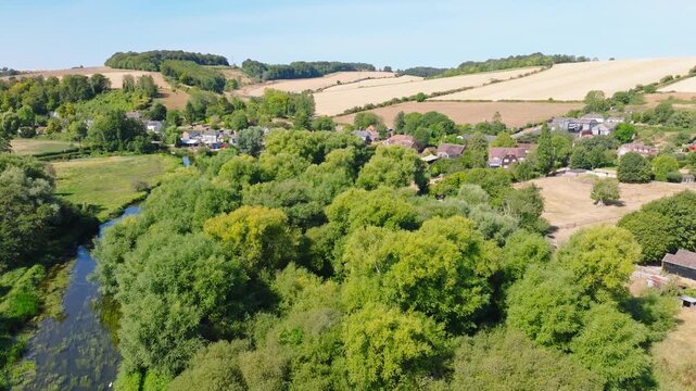 Aerial shot flying along the River Avon towards Upper Woodford village in summer. Wiltshire UK 