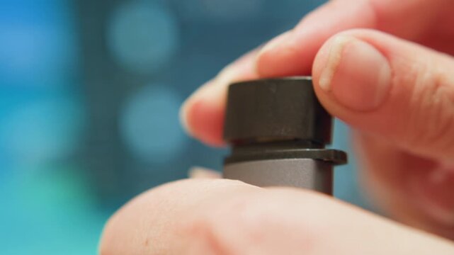 Careful fitting of protective cap. Precision in placing cap over adapter shaft carefully. Technician meticulously fits protective cover onto connector ensuring perfect alignment and tight seal