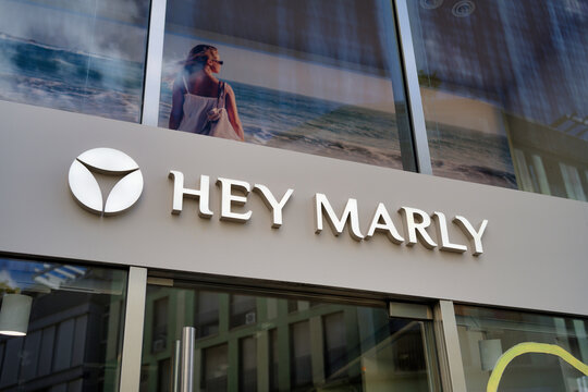 Cologne, Germany August 02 2026: Storefront and logo of fashion brand Hey Marly with beach advertising campaign poster in Cologne