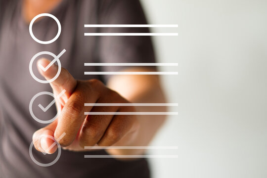 Close up of a man pointing his finger at a digital virtual checklist overlay. Concept of task management, goal achievement, quality control, online survey, and completing a to-do list.