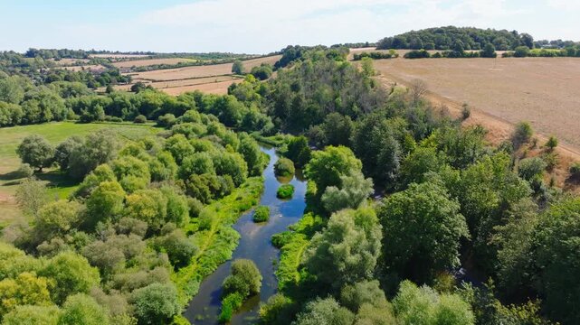 Aerial shot flying upstream along the River Avon from Upper Woodford towards Great Durnford, Wiltshire UK