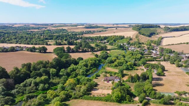 Aerial shot flying along the River Avon towards Upper Woodford village in summer. Wiltshire UK 