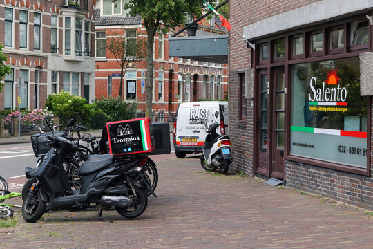 Food delivery scooters outside restaurants in Alkmaar, Netherlands