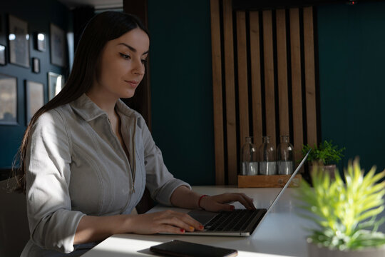 Focused woman working on laptop at home