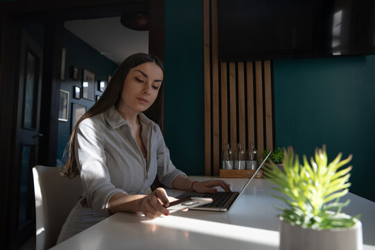 Woman multitasking with laptop and smartphone at home