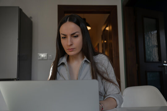 Focused professional woman working on laptop at home