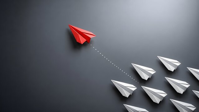 Taking a different direction and standing out concept with a red paper airplane breaking away from white planes on a dark background.