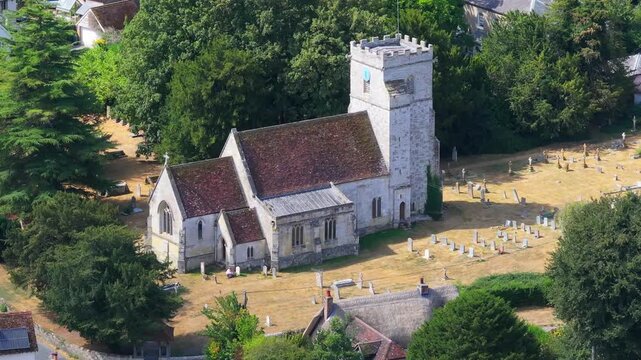 Telephoto aerial shot of All Saints parish church and graveyard in Middle Woodford, Wiltshire, UK