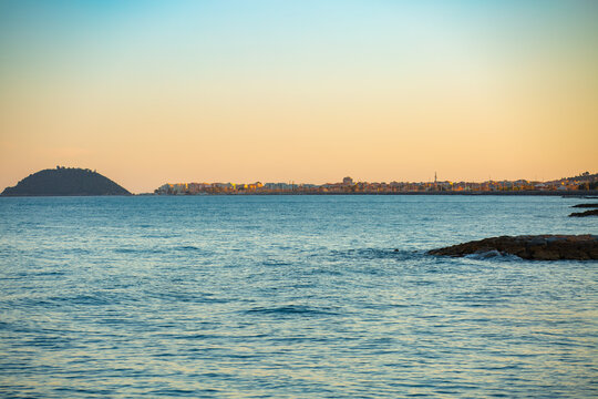 Panoramic sunset view of the village on the eastern Ligurian coast. Albenga, Galinara Island, Liguria, province of Savona. Stunning view of the sea and the village of Albenga with its colorful