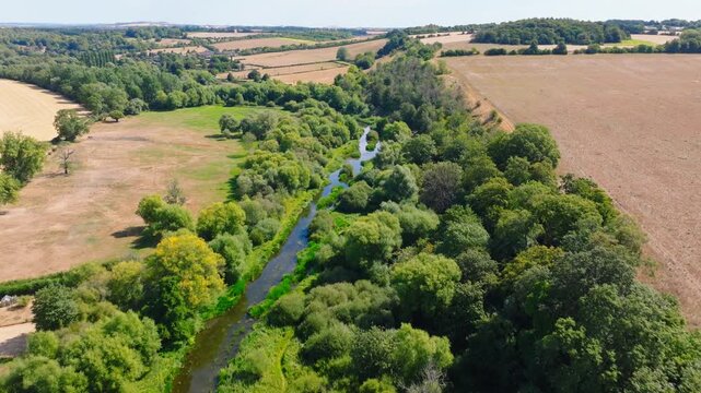 Aerial shot flying upstream along the River Avon from Upper Woodford towards Great Durnford, Wiltshire UK