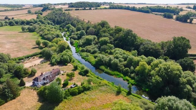 Aerial shot flying upstream along the River Avon from Upper Woodford towards Great Durnford, Wiltshire UK