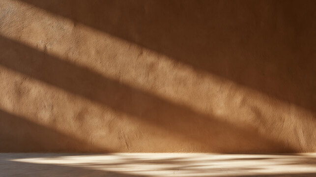 Sunlight and Shadow on Textured Ochre Plaster Wall Background