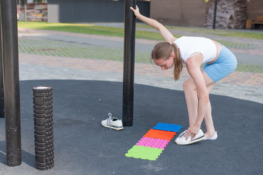 A woman with cerebral palsy walks on sensory mats. Rehabilitation