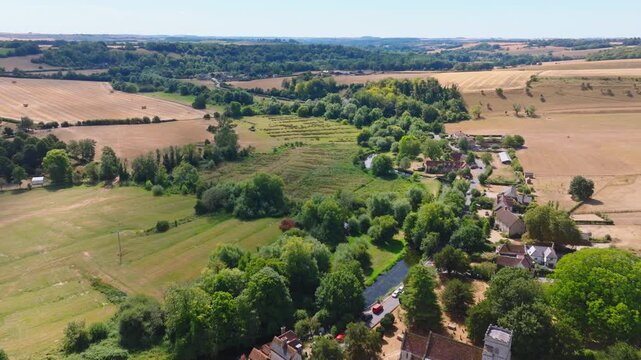 Aerial shot flying over the Woodford Valley south from Lower Woodford Village in summer, Wiltshire, UK
