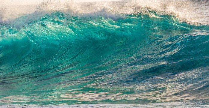 Stunning Turquoise Ocean Wave Curling Under Warm Golden Sunlight