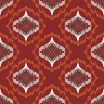 Seamless ethnic ikat pattern with burgundy red ogee floral medallion ornament. Embroidered stitch texture design for bohemian fabric, textile, apparel, wallpaper, and background.