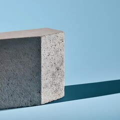 Fototapeta premium Off-center concrete block on pastel blue background