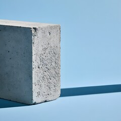 Fototapeta premium Off-center concrete block on pastel blue background