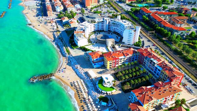 PORTO RECANATI, ITALY - JULY 30, 2025: Aerial pullback tilt-up shot of the beach. Apartment complexes, restaurants and seaside activities offer plenty of ease and entertainment to the visiting tourist