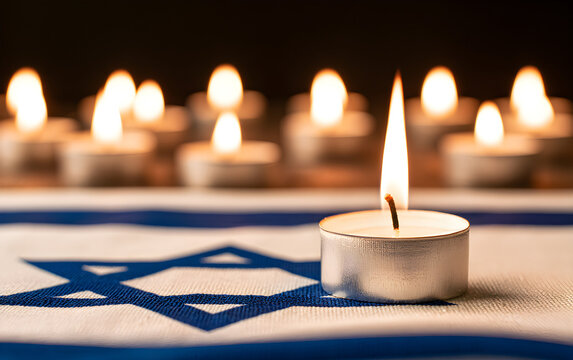 Burning candle and flag of Israel on black table. Holocaust memory day