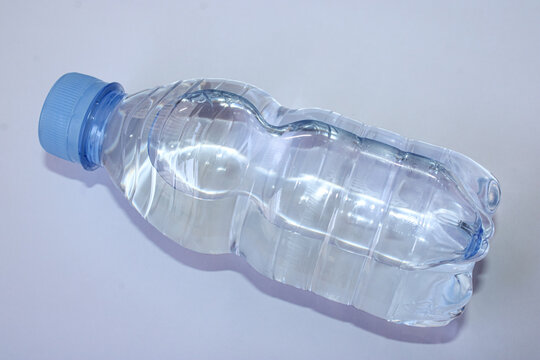 Clear Plastic Bottle Of Fresh Mineral Water Lying On White Background