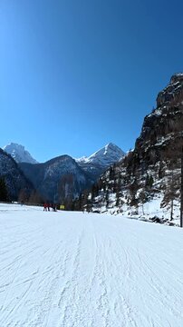 Point of view skiing down snowy slopes on a sunny day