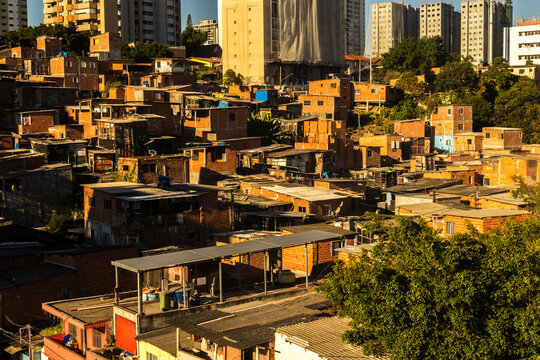 An aerial detailed view of the crowded Morro do Piolho favela community (also known as Sonia Ribeiro) composed of brick houses next to the Roberto Marinho Avenue