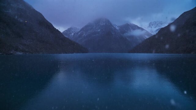 Snow falling over Gokyo Lake Nepal during a cold winter twilight