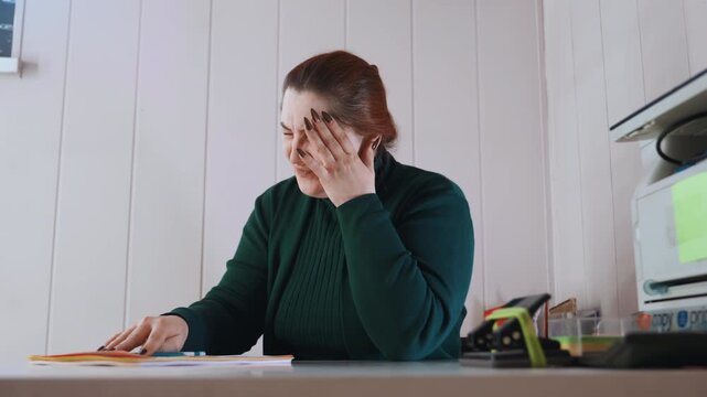 Worker struggles with paperwork fatigue. Office staff exhausted while handling forms and files. Fatigued employee attempting to concentrate despite discomfort and multiple pending assignments
