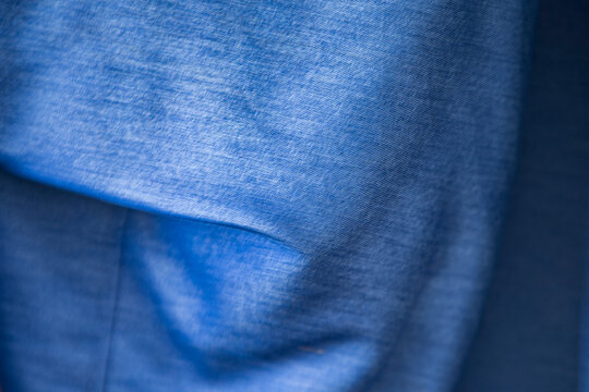 Close up texture of soft blue melange cotton fabric with gentle folds.A high-quality close-up shot showcasing the fine texture of a soft blue melange or heathered cotton fabric. 