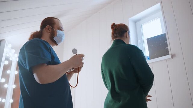 Post examination black paramedic comforts patient at home with reassuring touch and organized stethoscope on table, gentle handover and paperwork under soft vanity lights, calm exit preparations