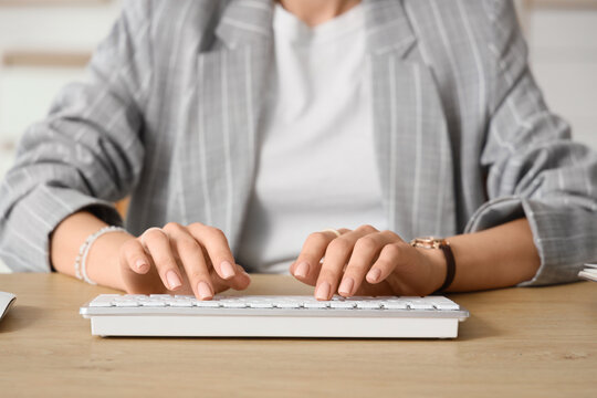Young businesswoman using computer to search online at desk in office, closeup