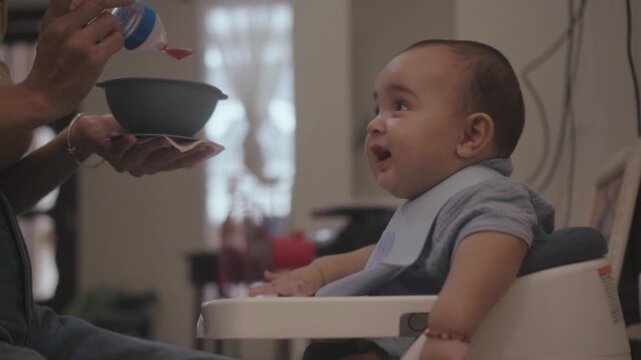 Mother feeding her toddler son with a spoon