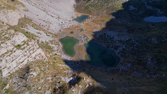 Drone shot of the Albanian albs mountain range with the peaks of the balkans trail. Rocky peaks and mountain lagoons.