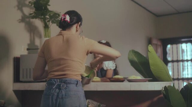 Hispanic mother serving lunch to her daughter in the kitchen