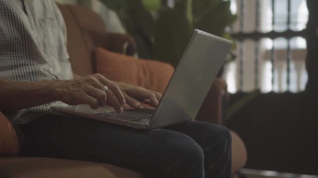 Person working on laptop from couch