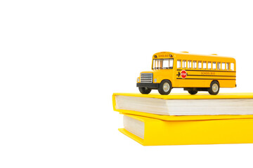 A school bus sits on top of two stacked books, isolated on white, PNG © Atlas