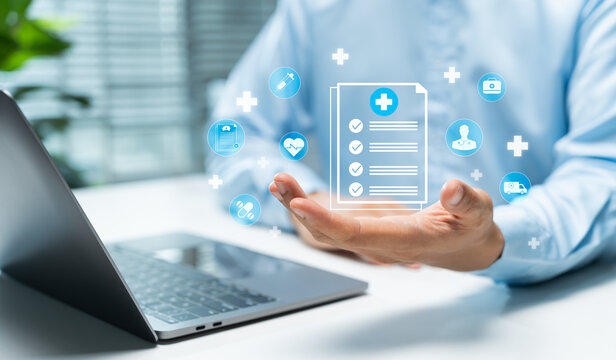 Healthcare professional uses a digital medical record interface beside a laptop, illustrating patient data, telemedicine, health insurance, clinical technology, and modern healthcare services.